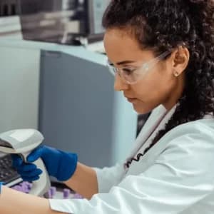 Scientist looking through a microscope in a lab